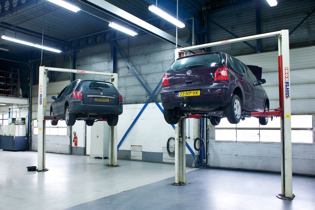 Twee auto’s hoog op de brug in de werkplaats